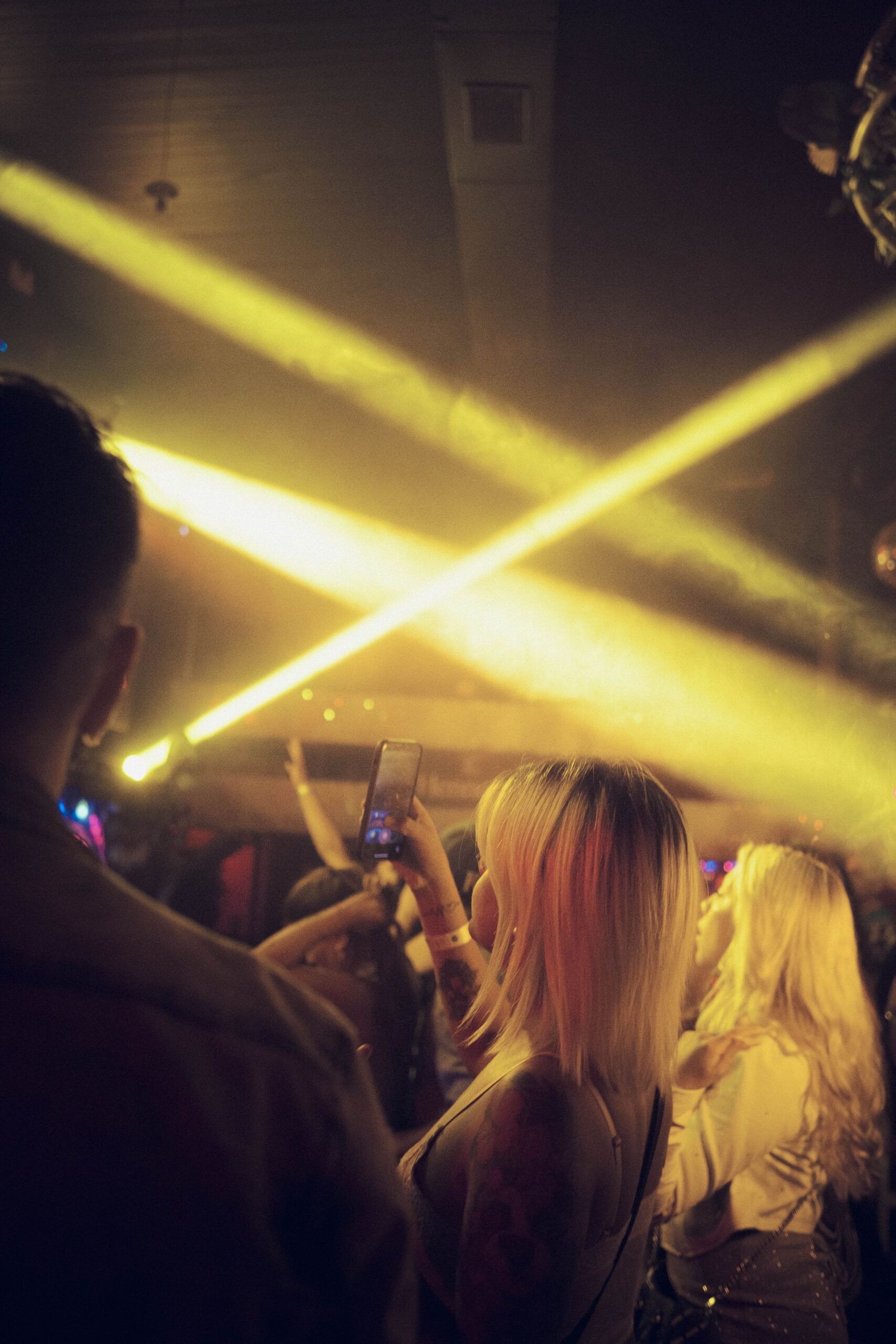 Pubblico sotto fasci di luce in un club